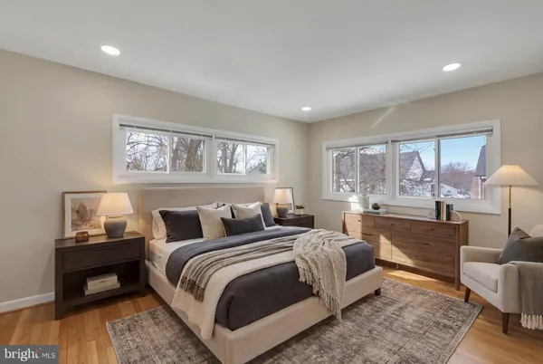 a spacious bedroom with a bed and wooden floor