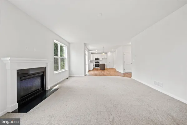 an empty room with a fireplace and a window