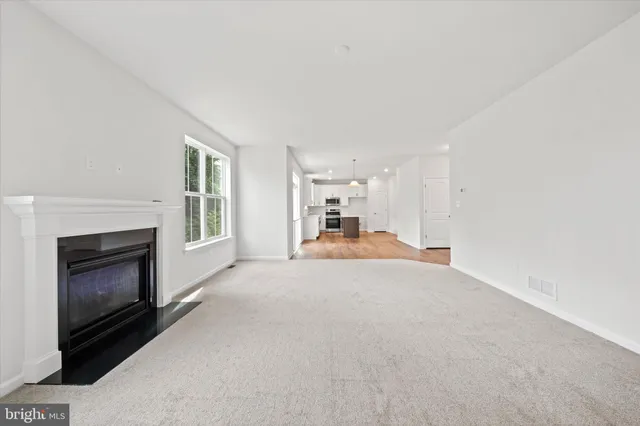 an empty room with a fireplace and a window