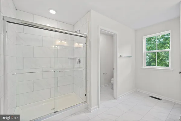 a bathroom with a shower sink and mirror