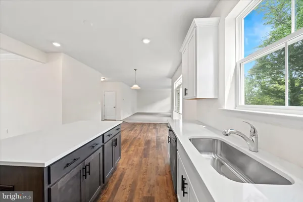 a view of a kitchen with a sink and large window