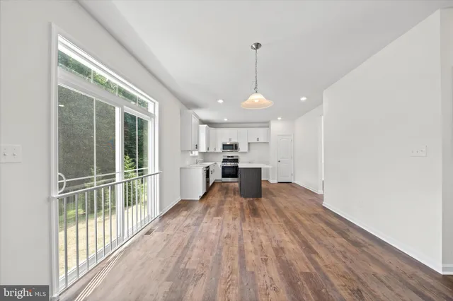 a view of large kitchen with wooden floor and windows