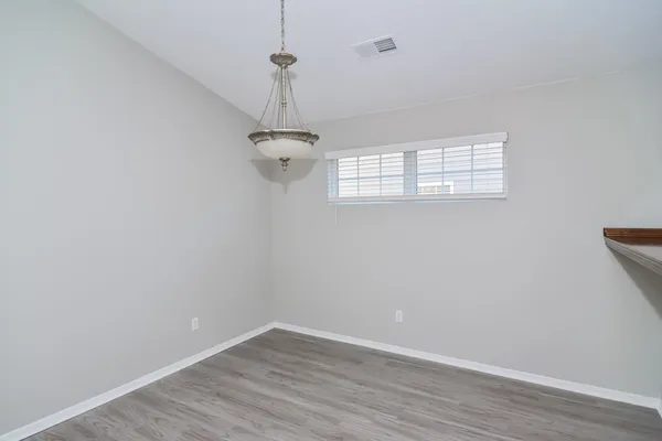 a view of a room with wooden floor a ceiling fan and window