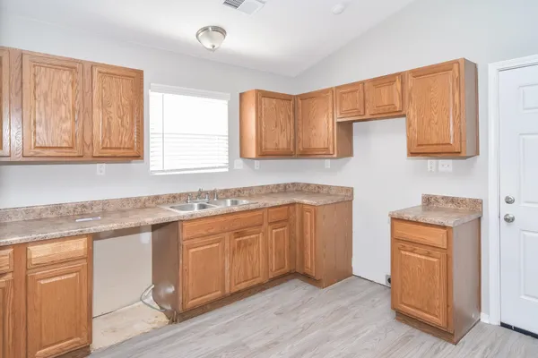 a kitchen with granite countertop a sink cabinets stainless steel appliances and a counter space