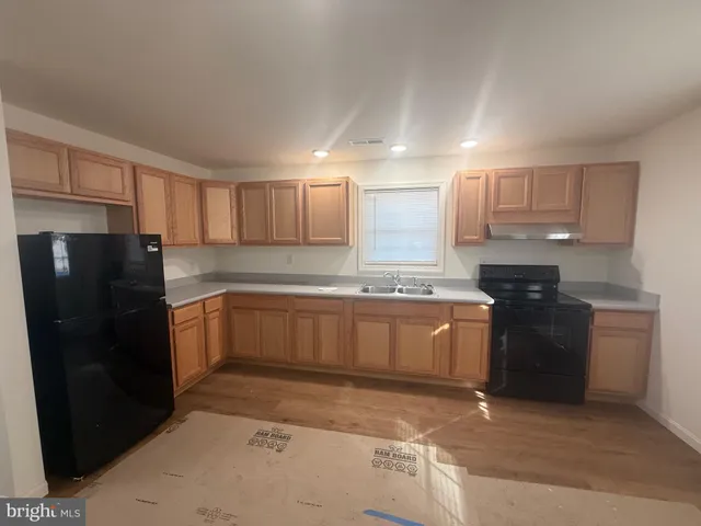 a kitchen with granite countertop white cabinets and refrigerator