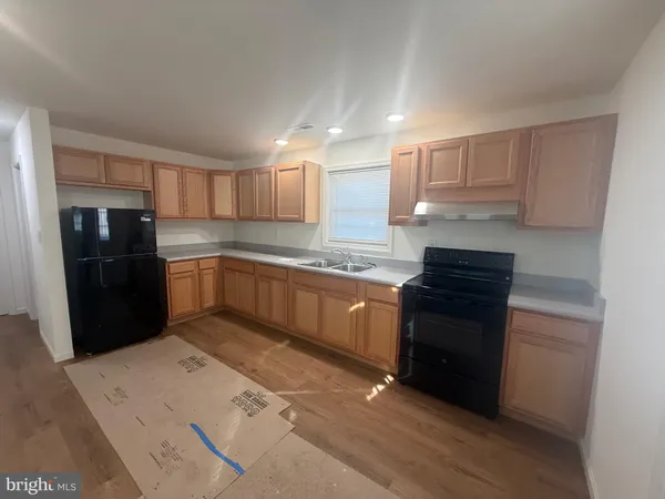a kitchen with granite countertop a refrigerator stove top oven and sink