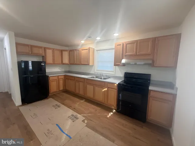 a kitchen with granite countertop a refrigerator stove top oven and sink