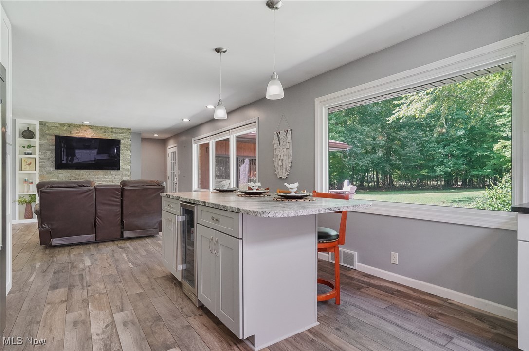 4555 Ranchwood Road Akron, OH 44333 - Photo 7 of 43 Kitchen with hanging light fixtures, a breakfast bar, light wood-type flooring, a center island, and recessed lighting