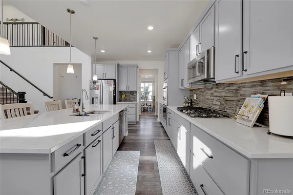 a large kitchen with stainless steel appliances lots of counter space and a sink