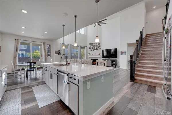 a large kitchen with stainless steel appliances kitchen island granite countertop a large counter top a sink a stove and a refrigerator