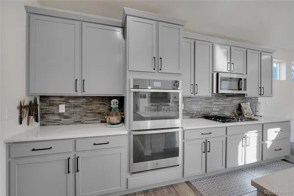a kitchen with white cabinets and white appliances