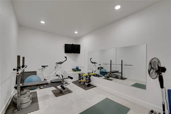 a room with gym equipment and a flat screen tv