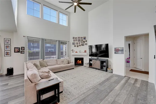 a living room with furniture a flat screen tv and a fireplace
