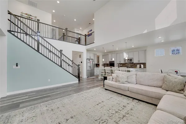 a living room with furniture and a dining table with kitchen view