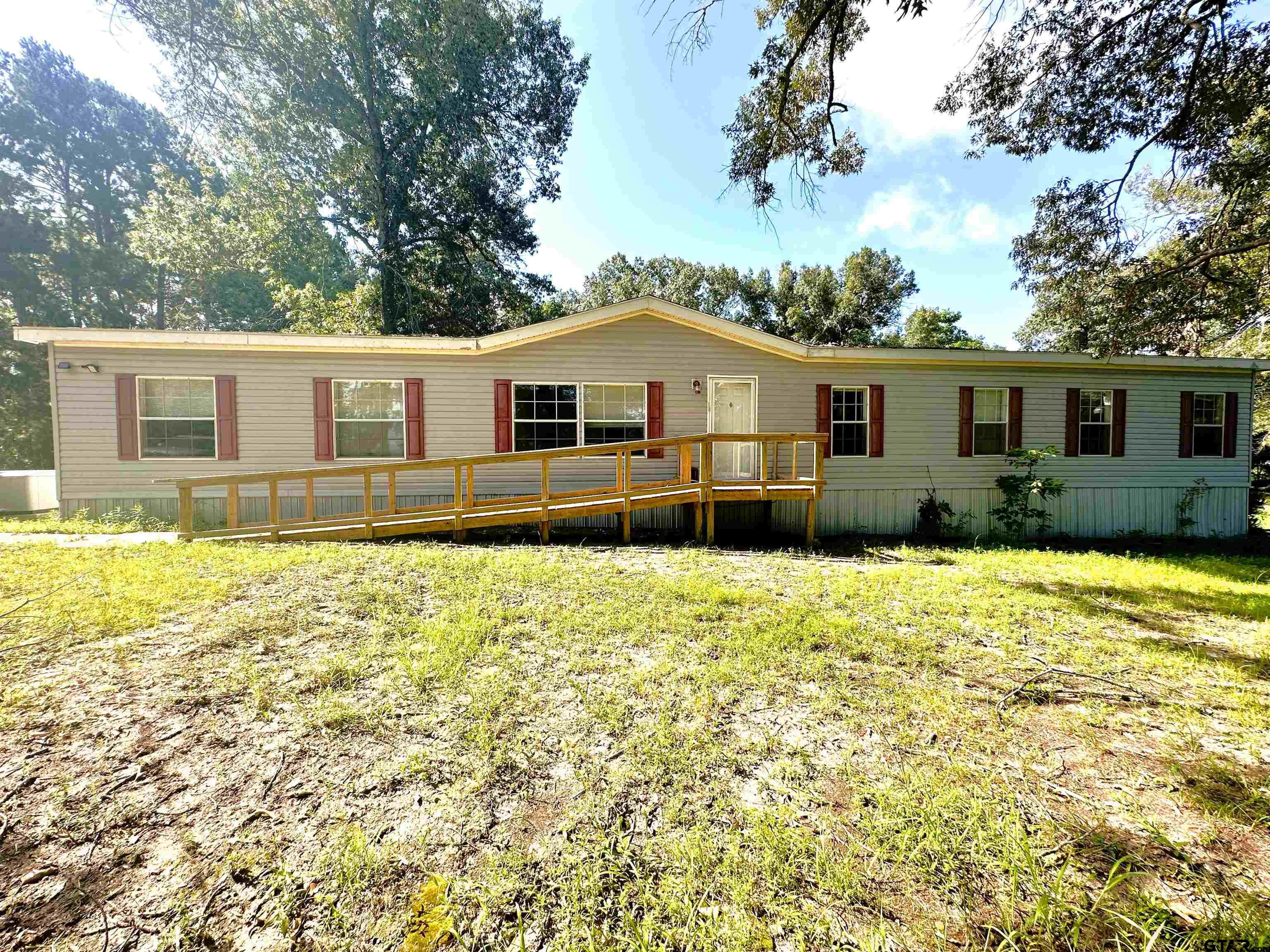 a front view of house with yard and trees around