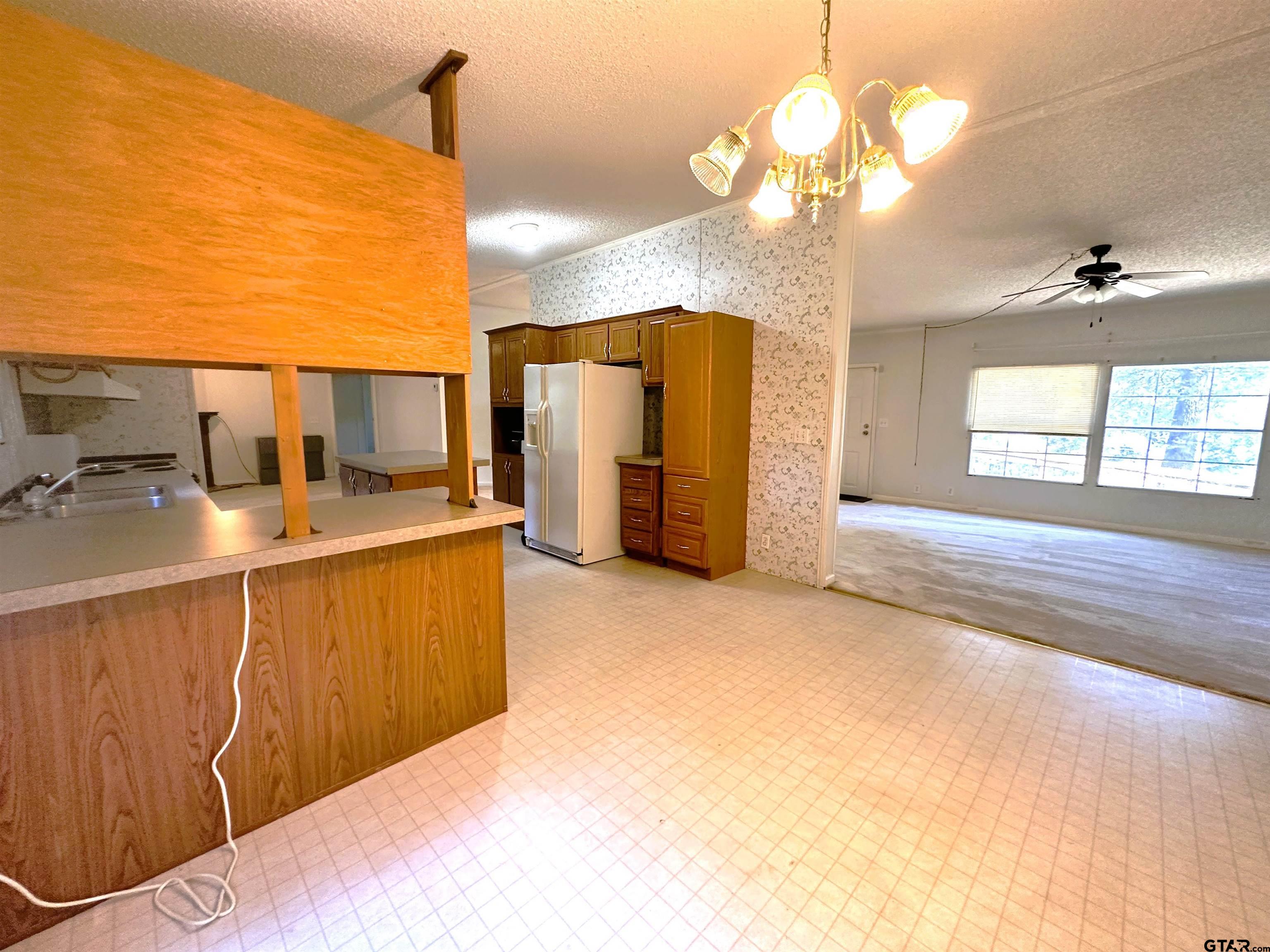 21232 Sand Jack Road Larue, TX 75770 - Photo 19 of 39 a kitchen with stainless steel appliances kitchen island granite countertop a sink cabinets and chandelier