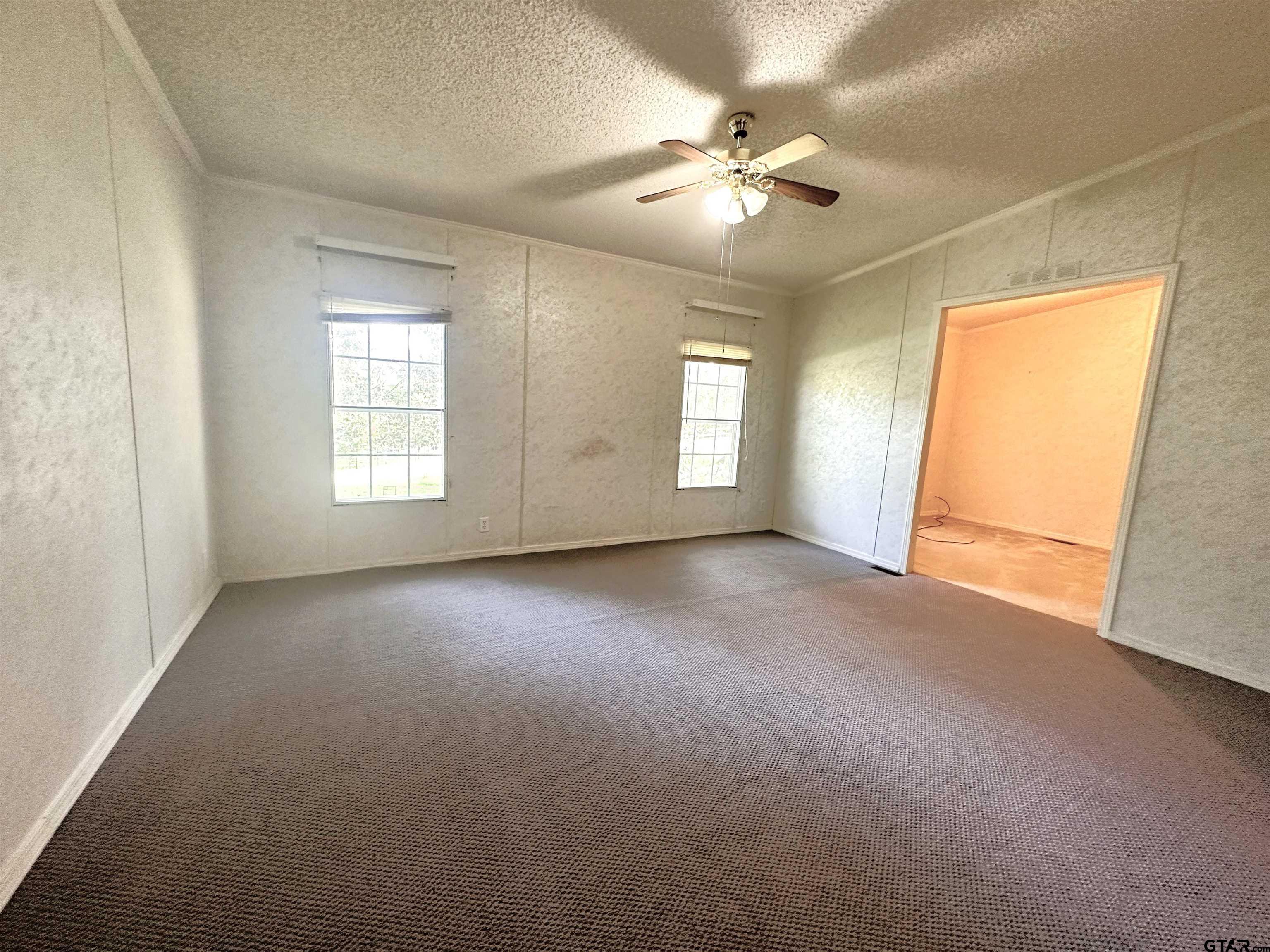 21232 Sand Jack Road Larue, TX 75770 - Photo 23 of 39 an empty room with windows and chandelier fan
