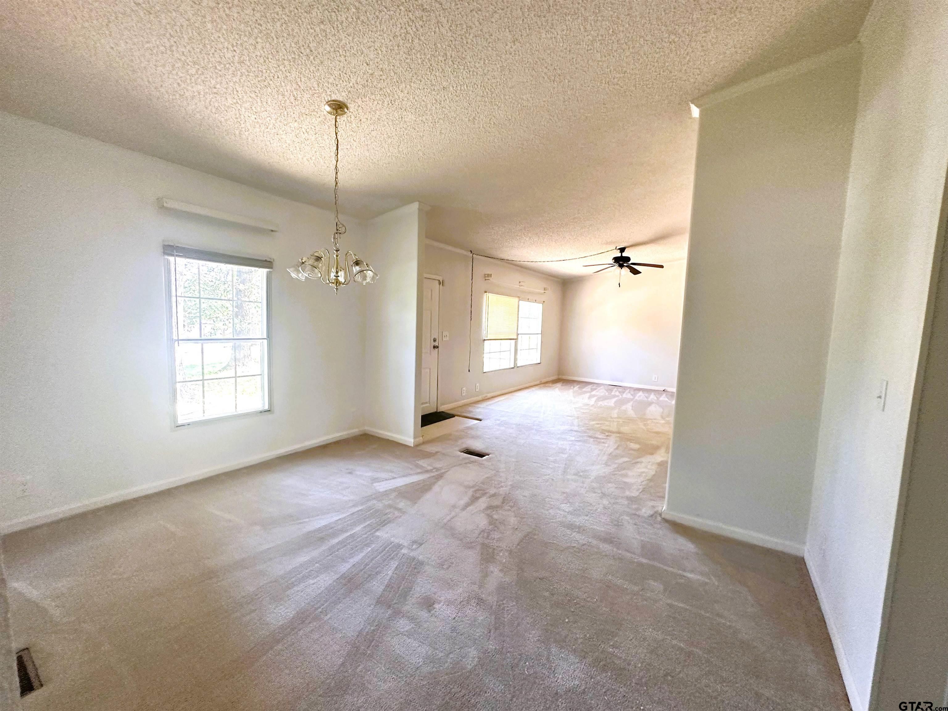 21232 Sand Jack Road Larue, TX 75770 - Photo 10 of 39 a view of a big room with windows and chandelier fan