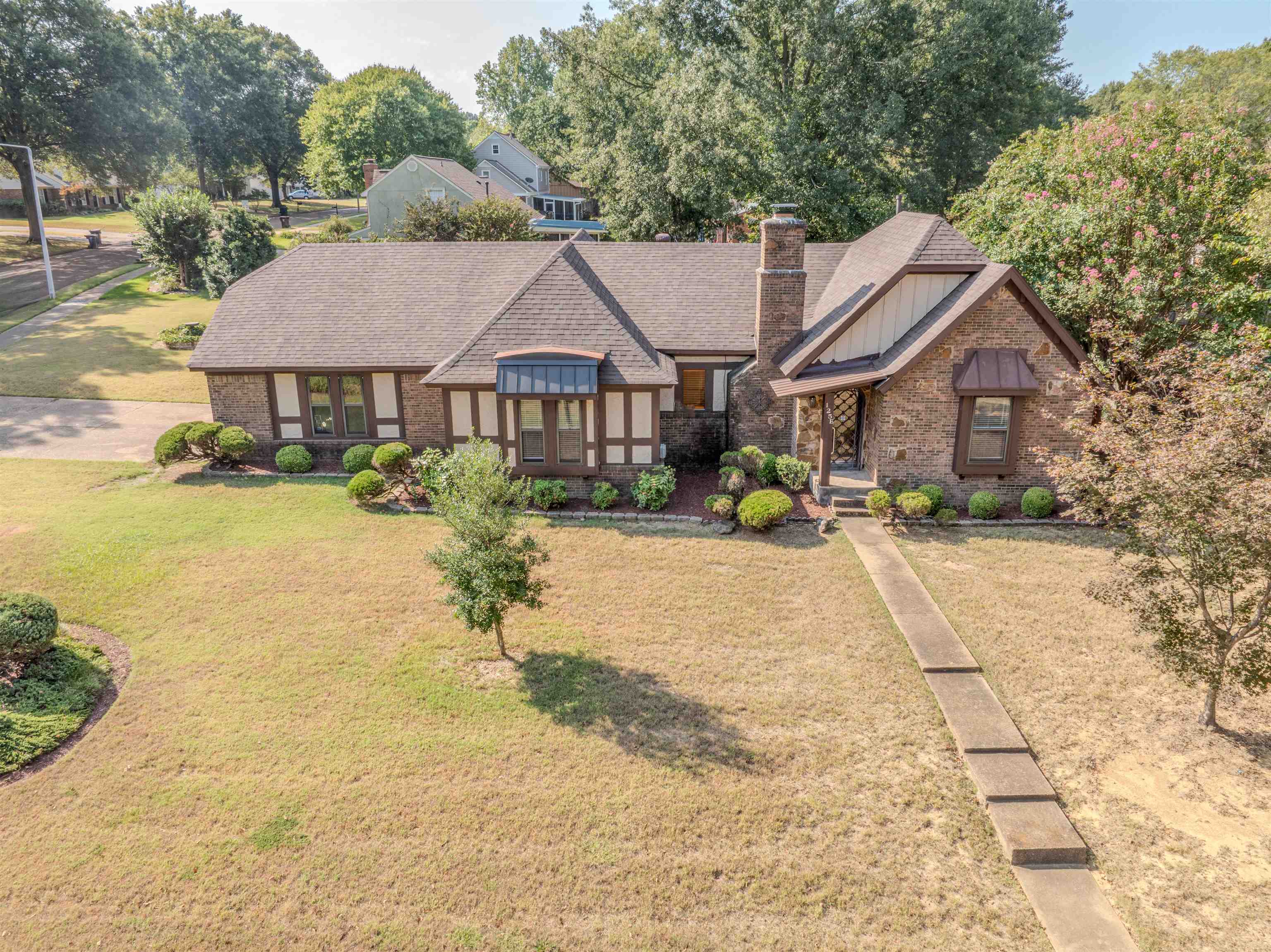 125 East Harpers Ferry Road Collierville, TN 38017 - Photo 5 of 40 Tudor house featuring a front yard, board and batten siding, a chimney, and roof with shingles