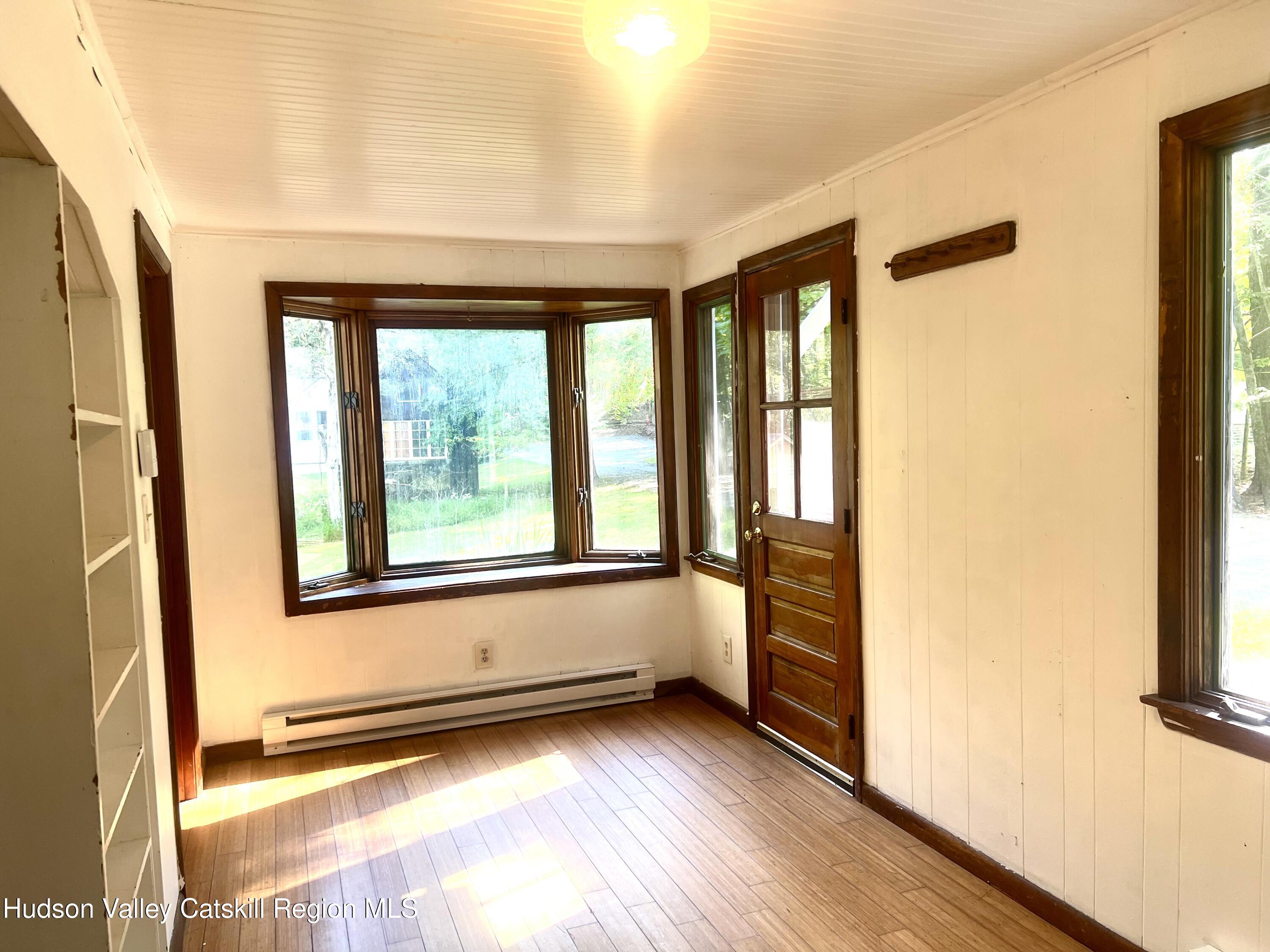 57 Ohayo Mountain Road Woodstock, NY 12498 - Photo 5 of 14 a view of an empty room with a window and wooden floor
