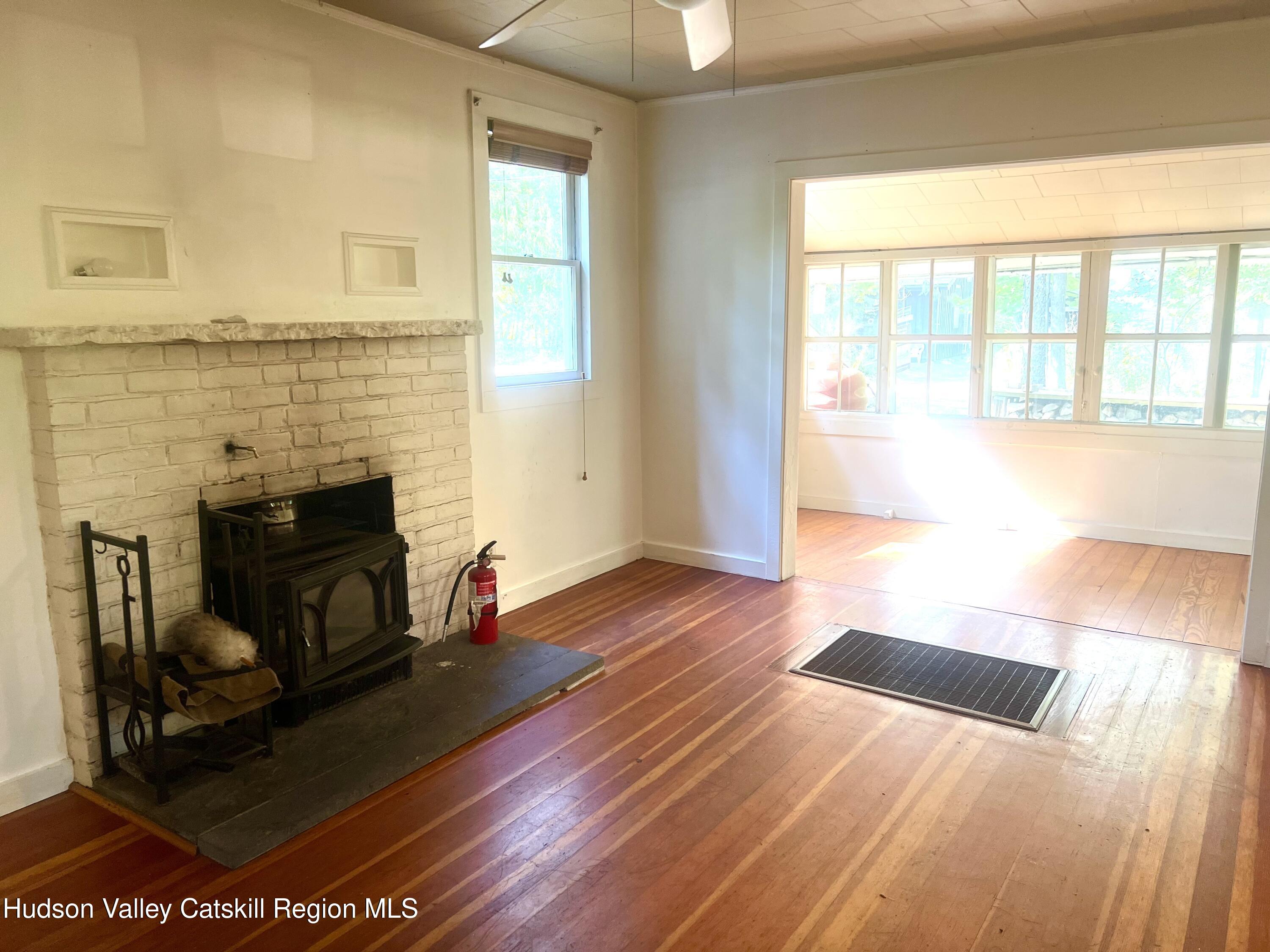 57 Ohayo Mountain Road Woodstock, NY 12498 - Photo 7 of 14 a view of an empty room with wooden floor and a fireplace