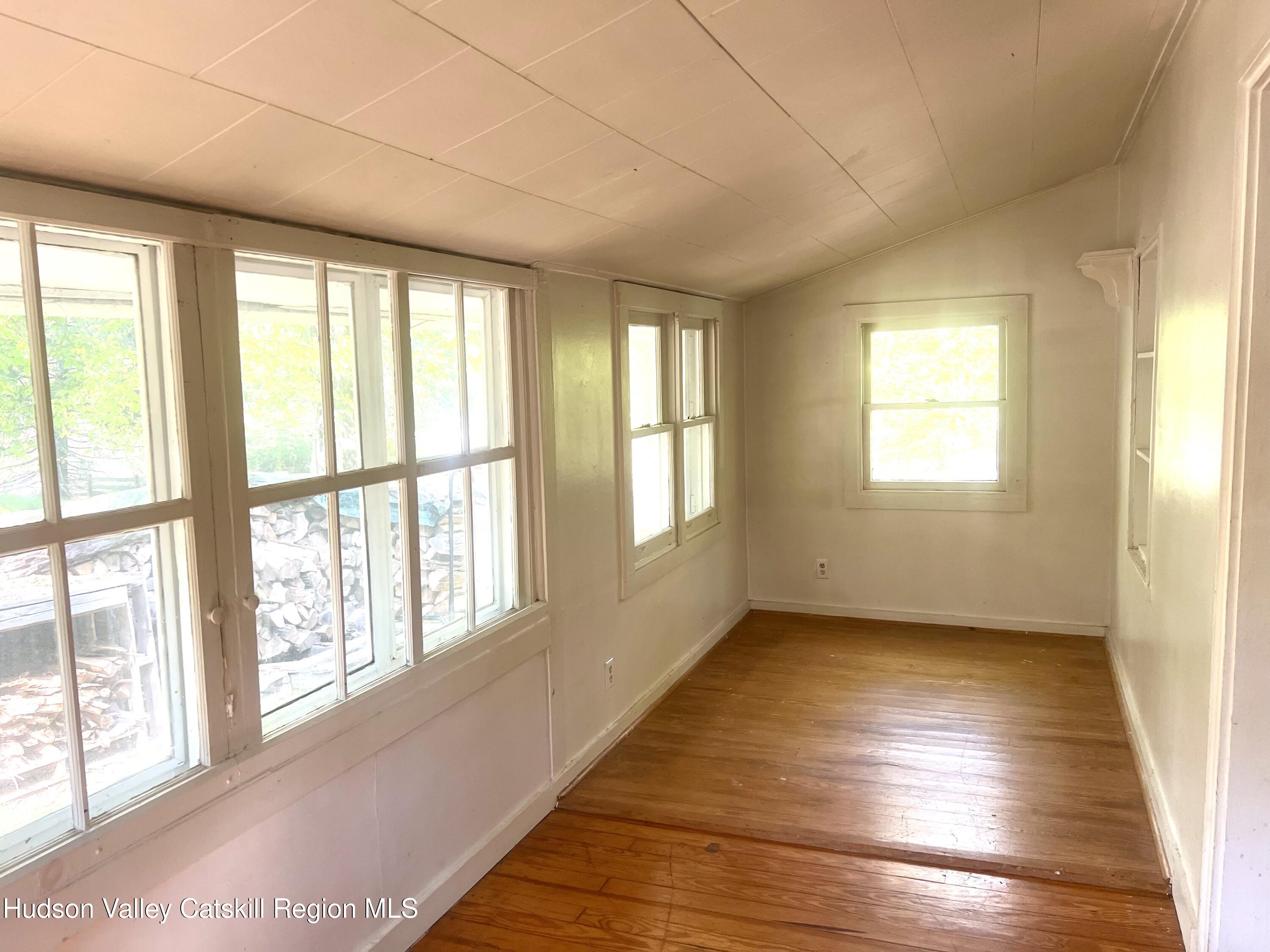 57 Ohayo Mountain Road Woodstock, NY 12498 - Photo 9 of 14 a view of an empty room with wooden floor and a window