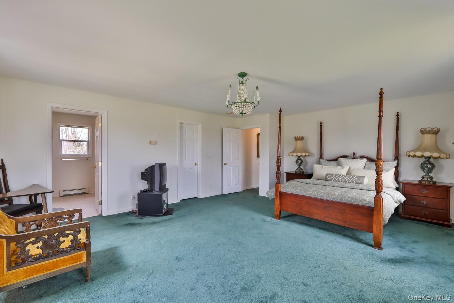 559 Case Road Ashland, NY 12496 - Photo 17 of 33 a spacious bedroom with a bed and a chandelier