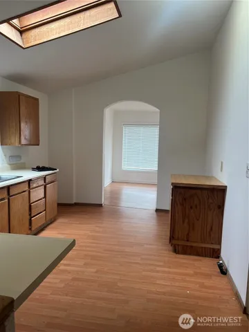 a view of a kitchen with wooden floor and electronic appliances