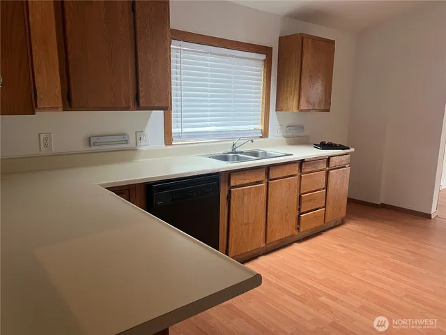a kitchen with a sink cabinets and wooden floor