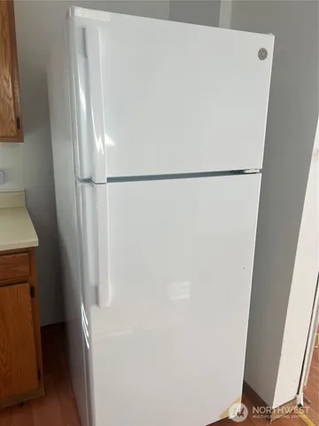 a white refrigerator freezer and a sitting area