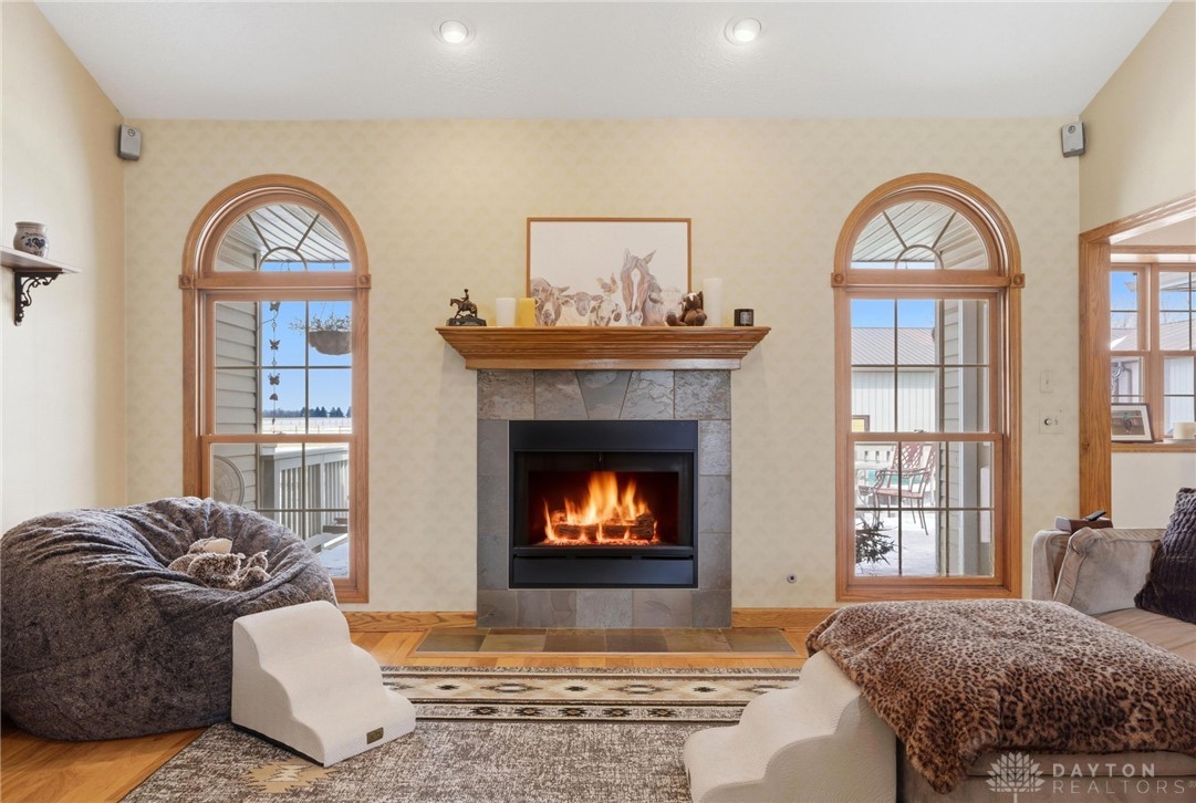1540 Jasper Road Xenia, OH 45385 - Photo 15 of 91 This inviting room features a fireplace flanked by arched windows, creating a cozy and luminous atmosphere.