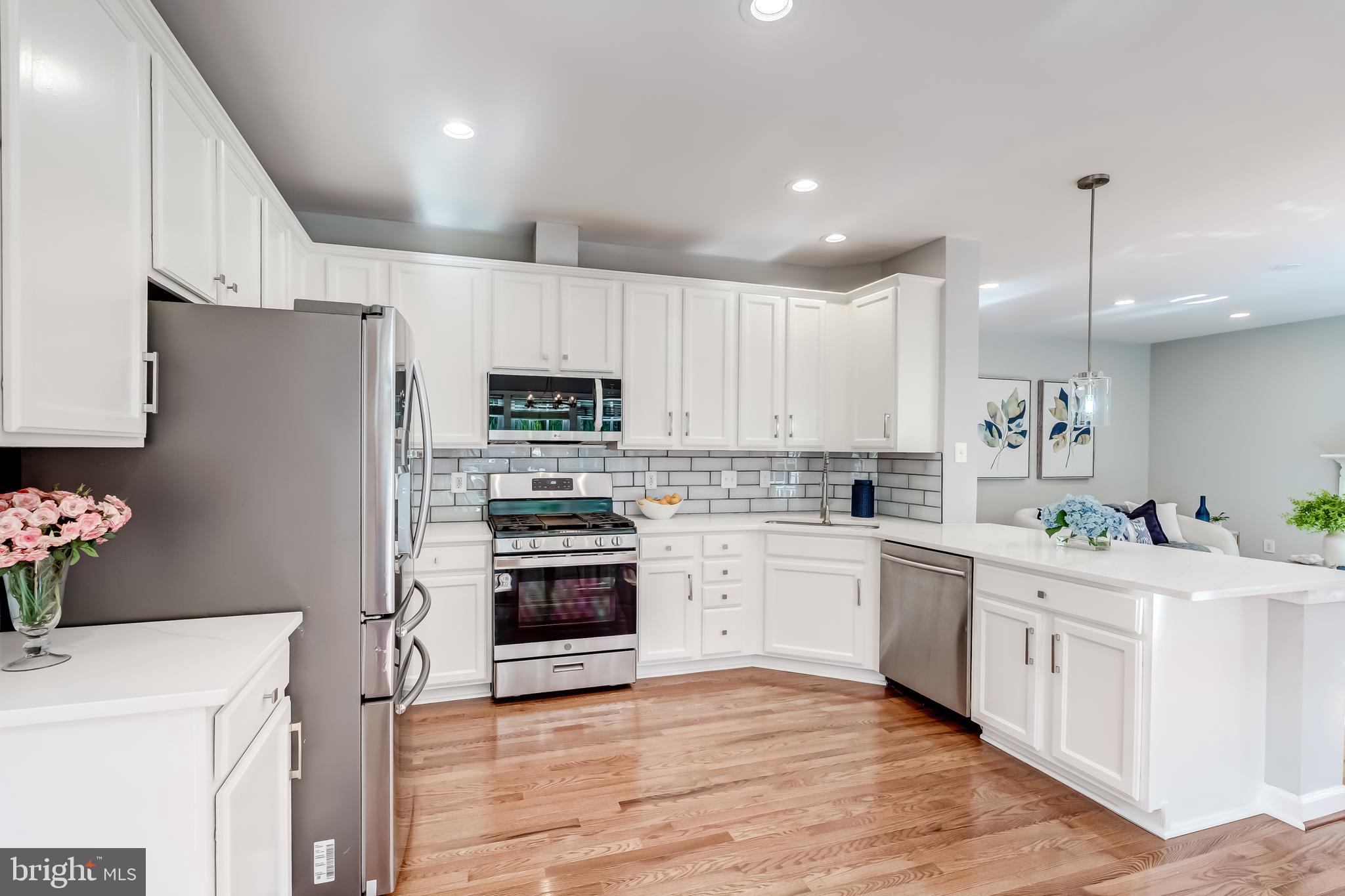 19111 Chartier Drive Leesburg, VA 20176 - Photo 13 of 68 a kitchen with white cabinets and white appliances