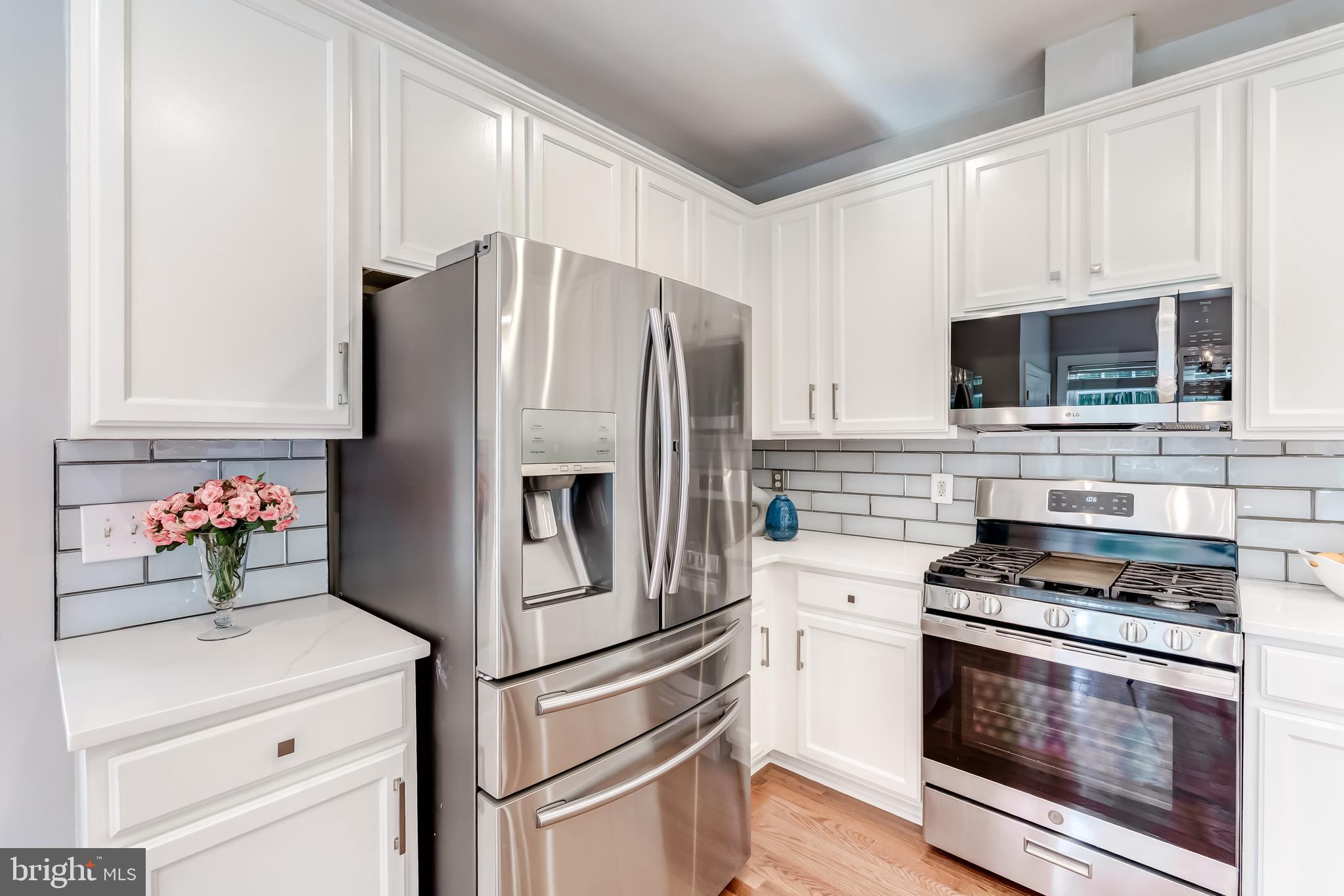 19111 Chartier Drive Leesburg, VA 20176 - Photo 15 of 68 a kitchen with cabinets stainless steel appliances and wooden floor