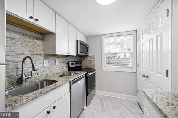 a kitchen with a sink cabinets and a window