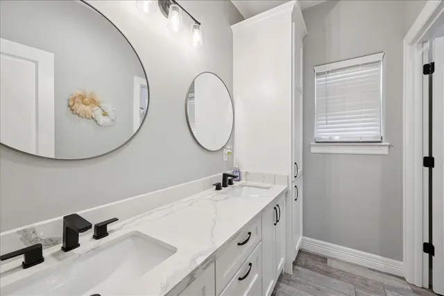 a bathroom with a double vanity sink and a mirror