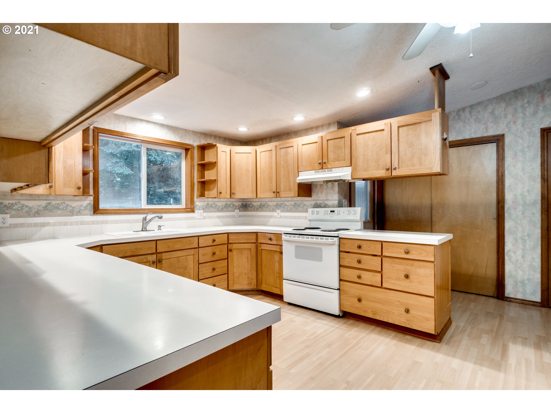 531 Oak Point Road Longview, WA 98632 - Photo 9 of 29 a kitchen with granite countertop white cabinets and white appliances