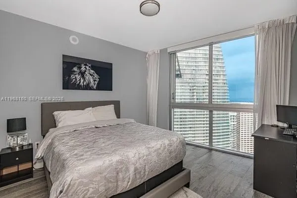 a bedroom with a bed and a large window