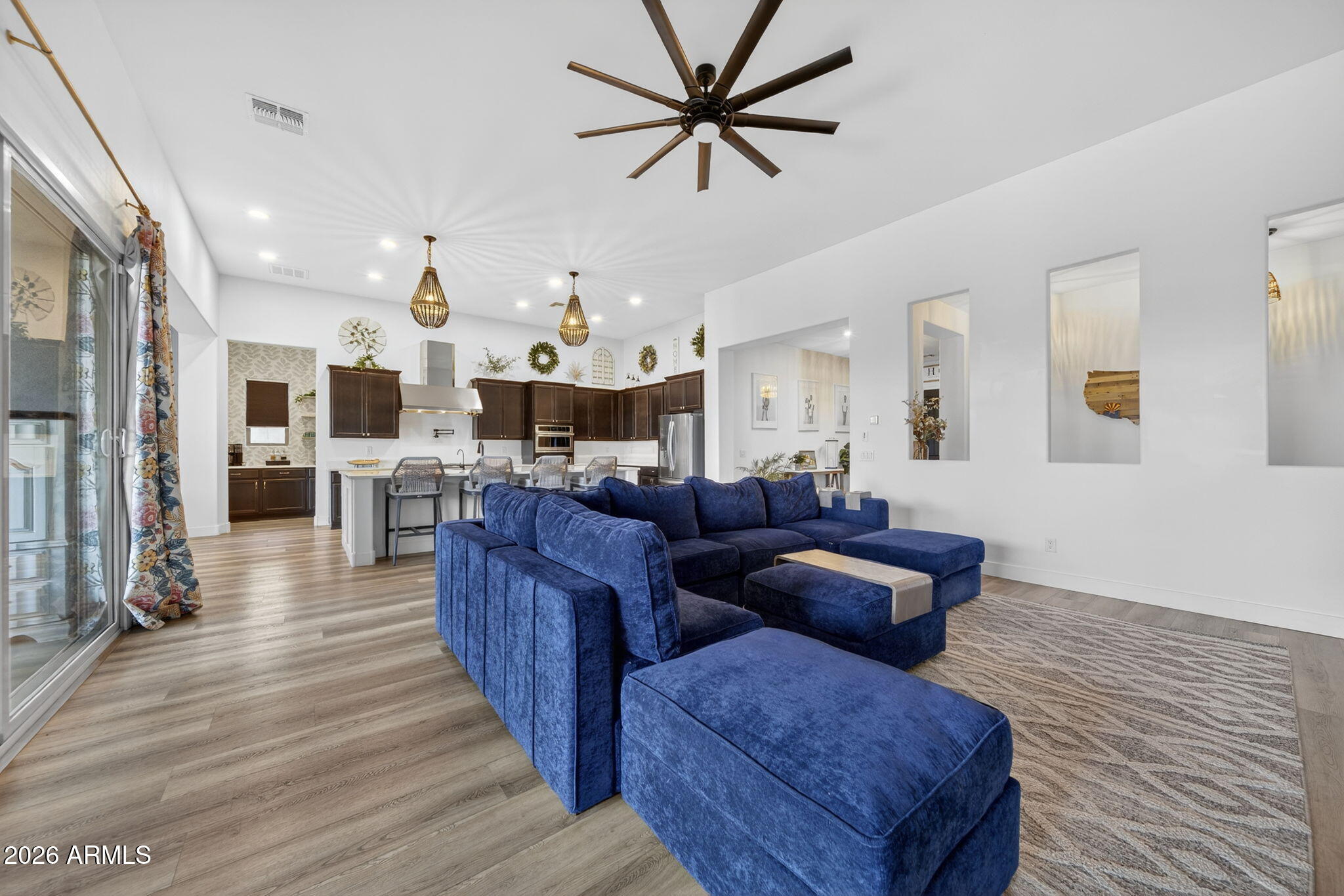 9932 East Rotation Drive Mesa, AZ 85212 - Photo 15 of 62 a living room with couches and kitchen view with wooden floor