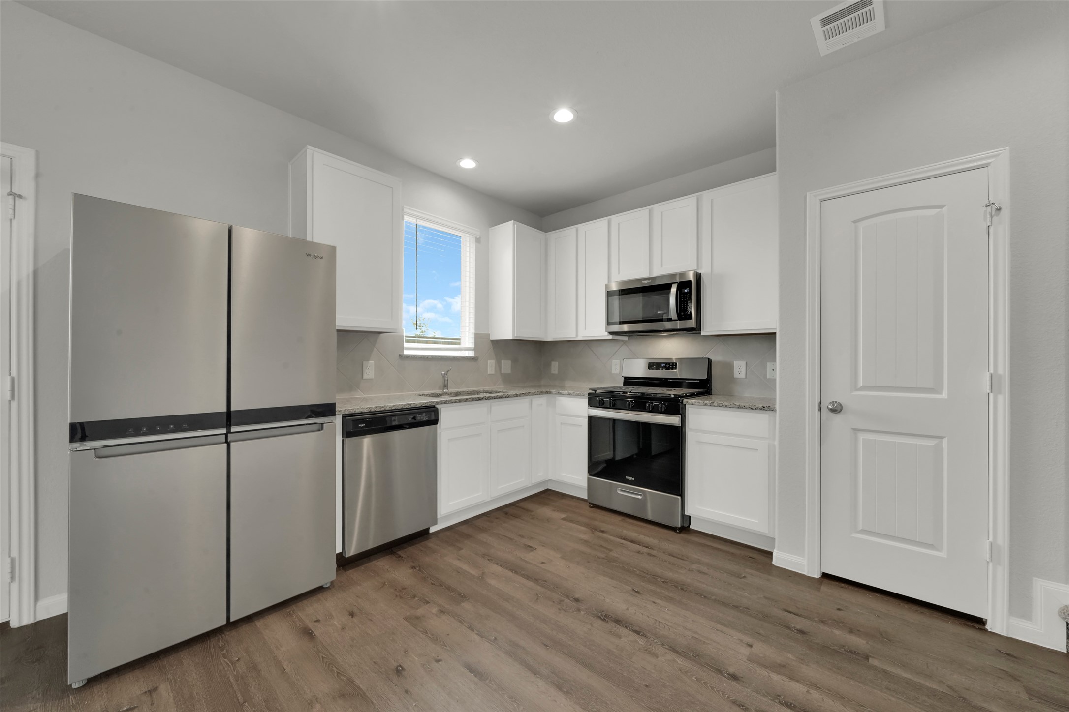 2542 Steelhead Drive Conroe, TX 77384 - Photo 5 of 20 Recessed lighting enhances the natural light to create an enjoyable cooking space. The convenient pantry will keep everything you need within easy reach.