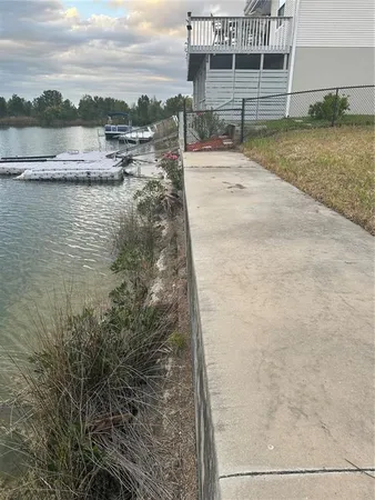 a view of a lake with a big yard and large trees