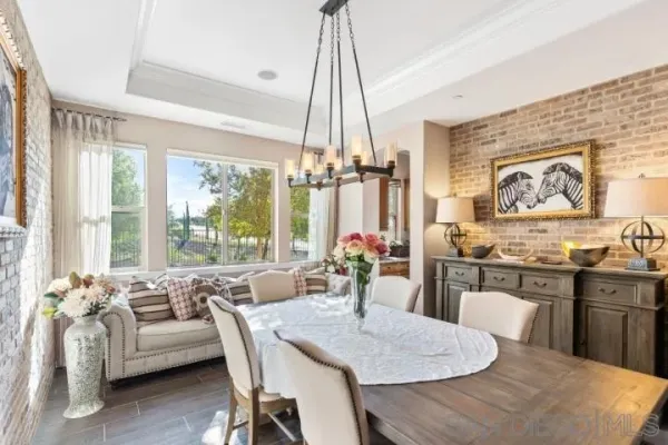 a kitchen with stainless steel appliances kitchen island granite countertop a table chairs and a view of living room