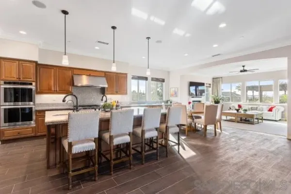 a living room with furniture ceiling fan and a large window