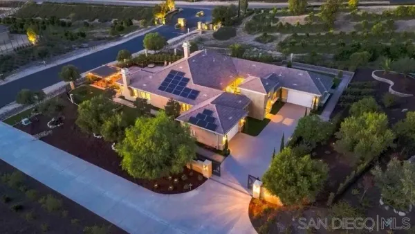 an aerial view of a house with a garden and lake view