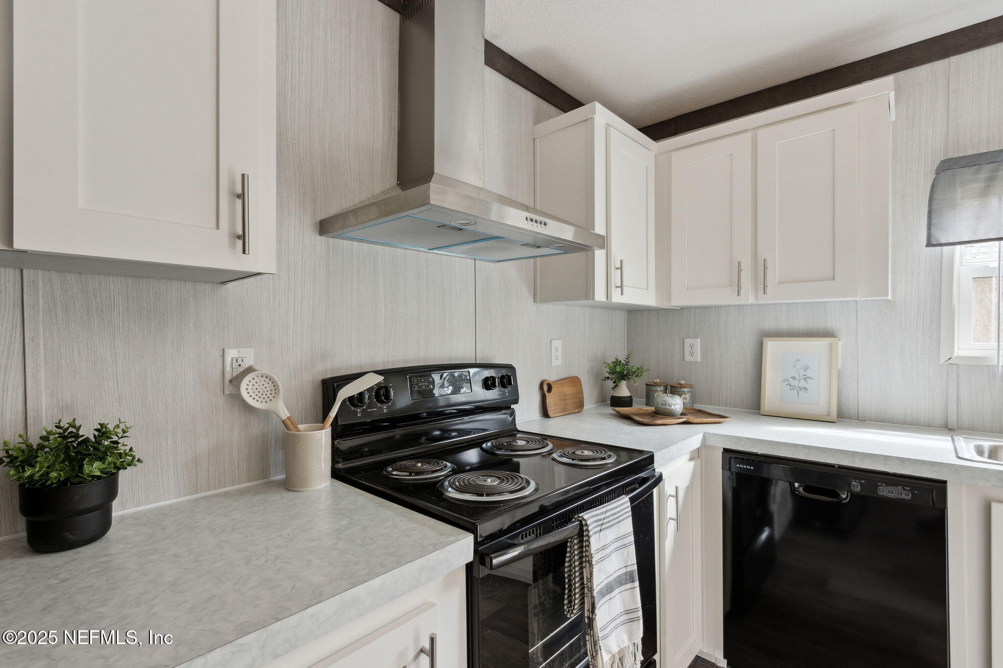 87454 Haven Road Yulee, FL 32097 - Photo 10 of 38 a kitchen with stainless steel appliances granite countertop a stove a sink dishwasher and white cabinets