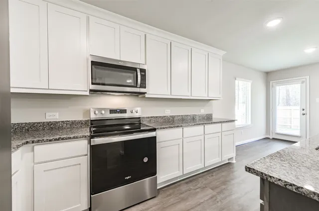 a kitchen with granite countertop cabinets stainless steel appliances and a sink