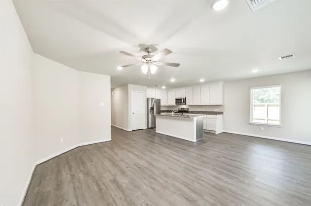 an empty room with wooden floor and window