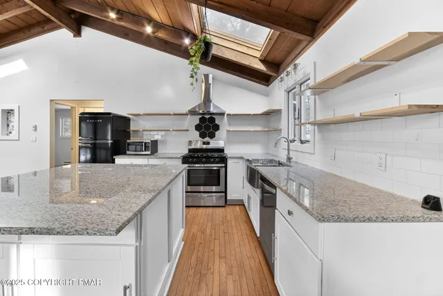 a kitchen with stainless steel appliances granite countertop a sink and stove