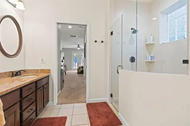 a bedroom with a bed and a lamp on dresser