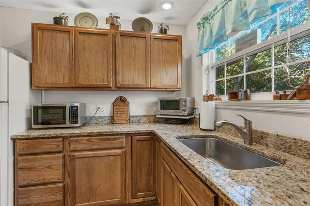 a front view of house with yard and trees in the background