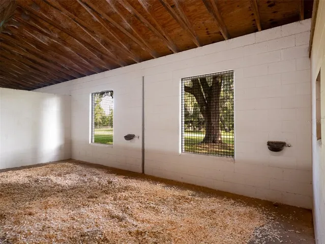 a view of swimming pool with outdoor seating and trees in the background